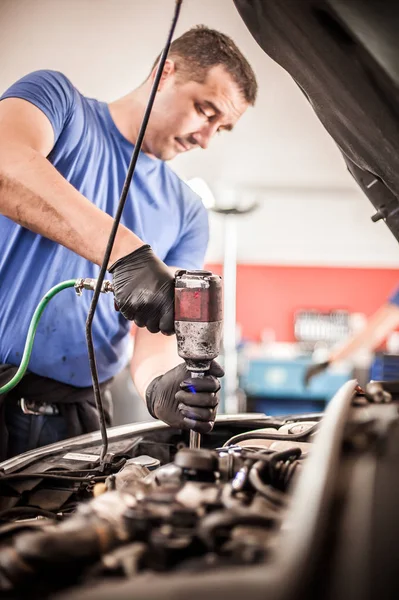 Автомеханик-ремонтник меняет свечи зажигания на автомобиле — стоковое фото