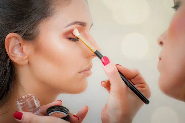 Maquillaje artista profesional aplicando sombra de ojos de color base en modo — Foto de Stock