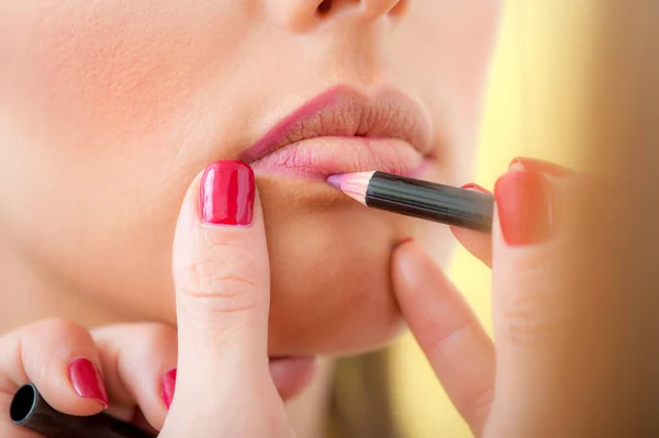 Maquillaje artista profesional aplicando lápiz labial en los labios con lápiz — Foto de Stock