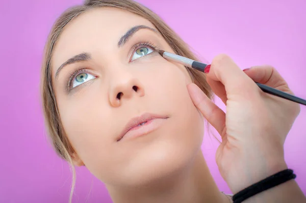 Maquillaje artista profesional aplicando sombra de ojos de color base en modo — Foto de Stock