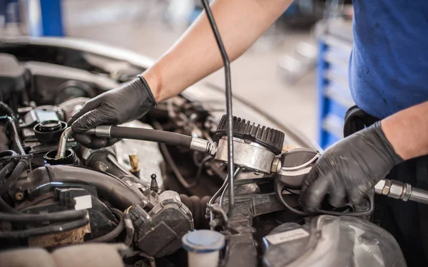 Автоматичний механічний ремонт вливає нове моторне масло в двигун автомобіля — стокове фото