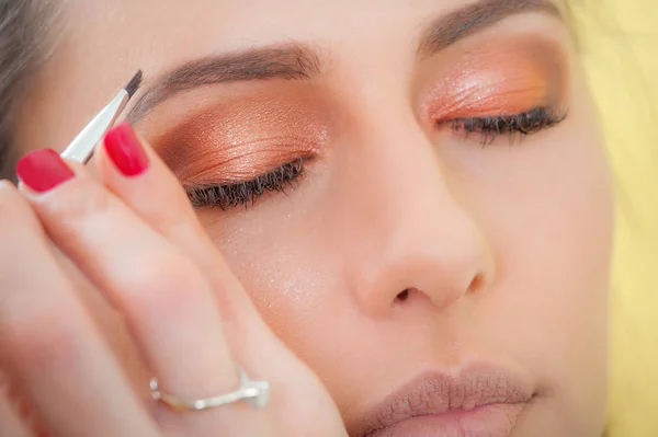 Makeup professional artist applying base color eyeshadow on mode