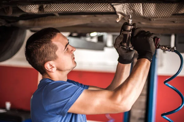 Reparador mecánico de automóviles que comprueba la condición bajo coche en el vehículo l —  Fotos de Stock