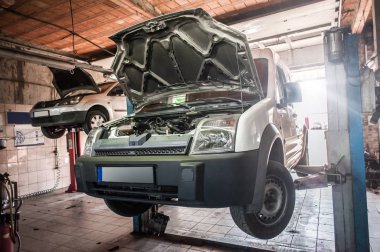 Araba tamirhanesinde hidrolik araba kaldırma sistemi var.