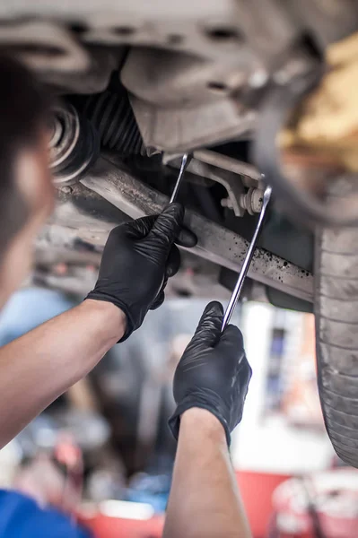 Auto mechanic repairer checking condition under car on vehicle l