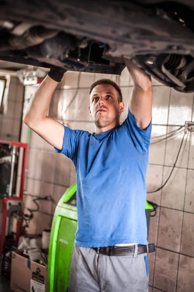 Reparador mecánico de automóviles que comprueba la condición bajo coche en el vehículo l —  Fotos de Stock