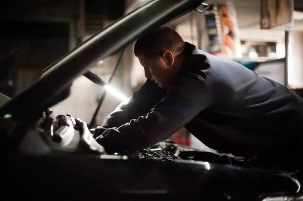 Autoopravář servisní technik kontroluje a opravuje auto — Stock fotografie