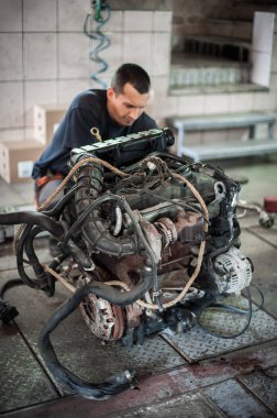 Arabadan çıkarılmış motor. Otomatik tamirci araba motorunu tamir eder
