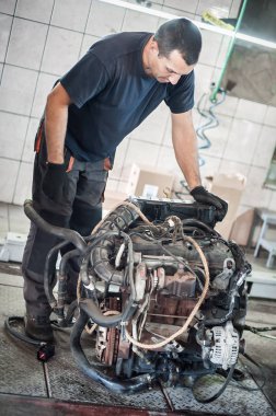 Arabadan çıkarılmış motor. Otomatik tamirci araba motorunu tamir eder
