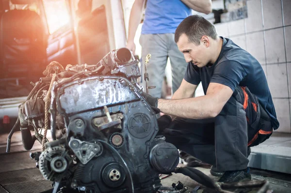 Usunięto silnik z samochodu. Dwa auto mechanika naprawy silnika samochodowego — Zdjęcie stockowe