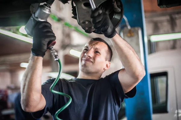 Reparador mecánico de automóviles que comprueba la condición bajo coche en el vehículo l —  Fotos de Stock