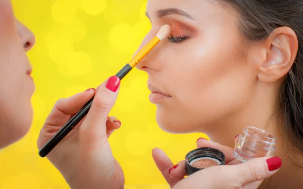 Maquillaje artista profesional aplicando sombra de ojos en modelo de mujer — Foto de Stock