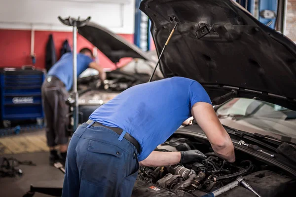 Dos reparadores mecánicos de automóviles técnico de servicio reparaciones auto engin —  Fotos de Stock