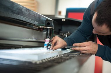 Elektrik mühendisi büyük CNC bilgisayar sayısal kontrol yazdırma ve kesme makinesinin lazer kesme başını onardı