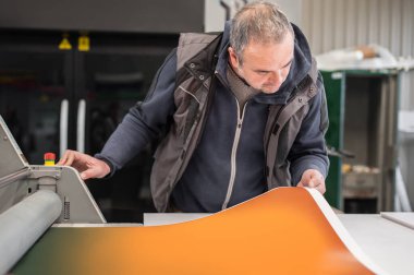 İşçi matbaa teknisyeni, birçok farklı türde makine ile büyük dijital baskı basın salonu ve matbaa ofisinde çalışır.