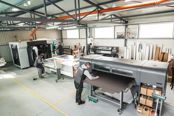 Geniş bir grup işçi matbaa teknisyeni dijital matbaa ve matbaa ofisinde çalışıyor.