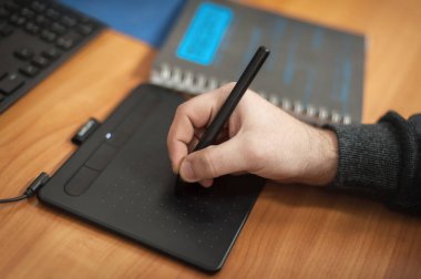 Grafik tasarımcılarının yakın plan detaylı görünümü ve 3D program animasyoncuları el, ofiste grafik tablet ve bilgisayarlar üzerinde çalışma