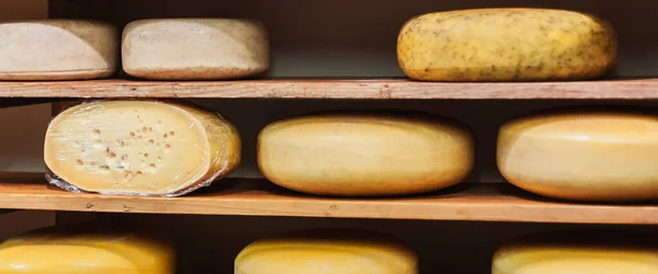 Traditional Dutch cheese displayed for sale in an Amsterdam shop in the Holland.The Netherlands produces a variety of the hard or semi-hard tempting cheeses