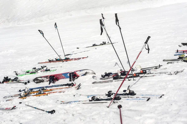 许多滑雪板 杆子和雪板 粘在雪地里 旁边是山坡上的滑雪场 侧视图 — 图库照片