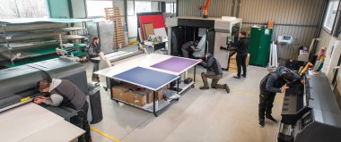 Geniş bir grup işçi matbaa teknisyeni dijital matbaa ve matbaa ofisinde çalışıyor.