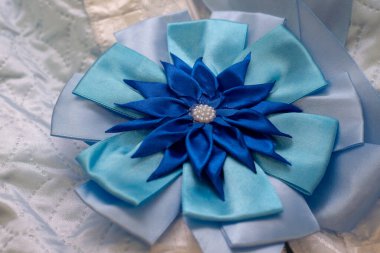 Masanın üzerinde mavi kurdele olan hediye kutusu.