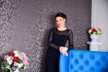 Şık siyah elbiseli güzel esmer kadın. Lüks içinde poz veriyor.