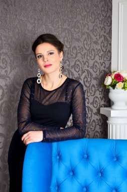 Şık siyah elbiseli güzel esmer kadın. Lüks içinde poz veriyor.