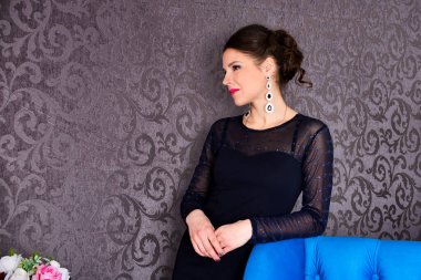 Şık siyah elbiseli güzel esmer kadın. Lüks içinde poz veriyor.