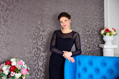 Şık siyah elbiseli güzel esmer kadın. Lüks içinde poz veriyor.