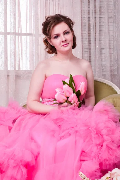 beautiful brunette in a luxurious pink dress