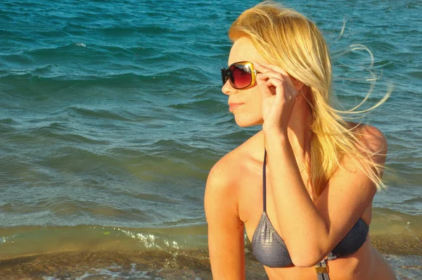 Chica en bikini en la playa cerca del mar —  Fotos de Stock