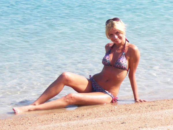 Chica en bikini en la playa cerca del mar — Foto de Stock