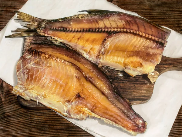 Uzené ryby stockfish na dřevěném prkénku — Stock fotografie