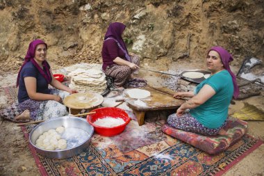 Kadınlar lavaş hazırlar ve açık ateşte pişiririm.