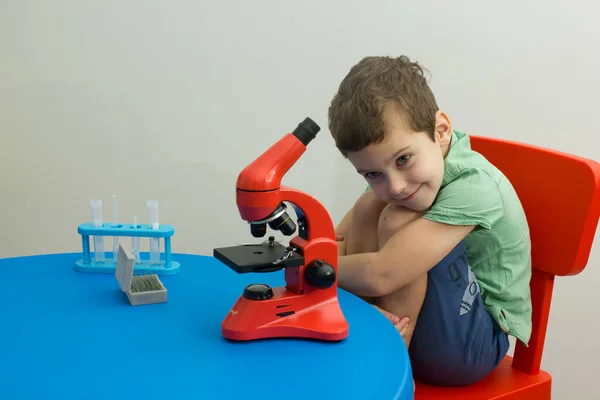 Química. Ciencia. Experimento. Educación. Estudia. Niño inteligente trabajando con microscopio y tubos de ensayo. Niño pequeño con tubos de ensayo. Tecnología moderna — Foto de Stock