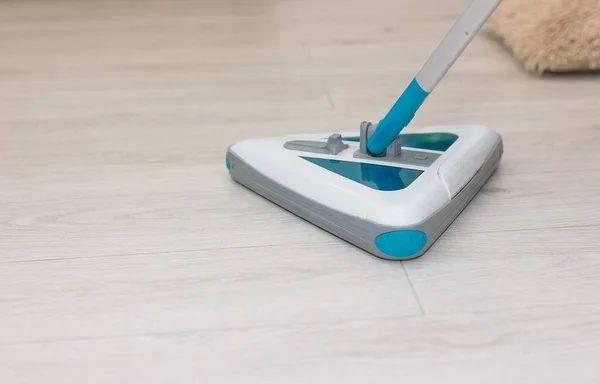 Hafif laminatın arka planında elektrikli süpürge. Yerler temiz. Dezenfekte. Konsept temizlik şirketi. Metin için boşluk