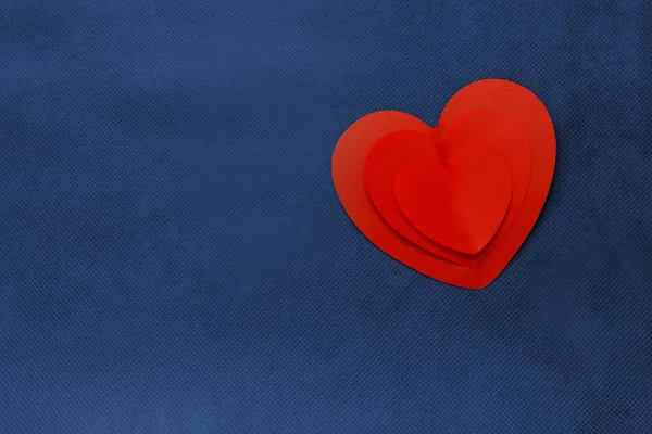 Dreifachherz auf blauem Hintergrund. Phantomblauer Hintergrund, Konzept Valentinstag — Stockfoto