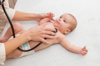 Pediyatrist yeni doğan bebekleri dinler. Küçük bir çocuğun fiziksel muayenesi