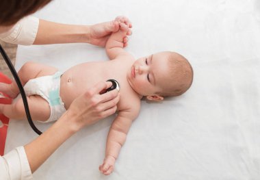 Pediyatrist yeni doğan bebekleri dinler. Küçük bir çocuğun fiziksel muayenesi