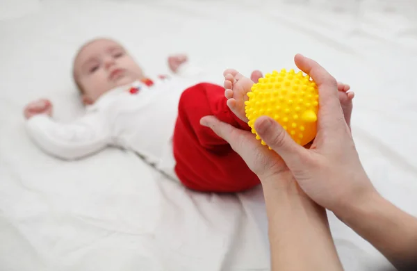 Annelerin ellerinde bebek ayakları. Sarı topla ayak masajı yapmak. Aşkın Kavramı
