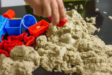 3 yaşındaki sevimli küçük çocuk evde kinetik kum oynuyor..