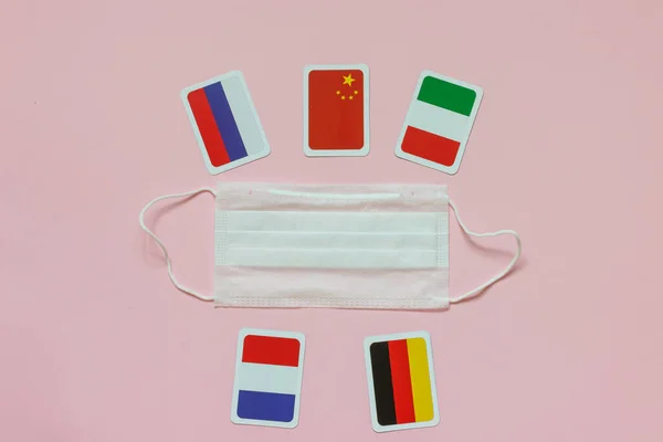 意大利 俄罗斯 德国等国的国旗 中国的保护性医疗面具 粉色背景 Quot 团结各国对抗科罗纳韦勒斯流行病2019 Quot 的概念 — 图库照片