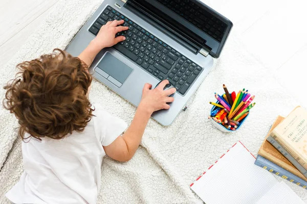 Curly Boy Watching Monitor vista superior. Concepto de formación, educación a distancia durante la cuarentena COVID 19 —  Fotos de Stock