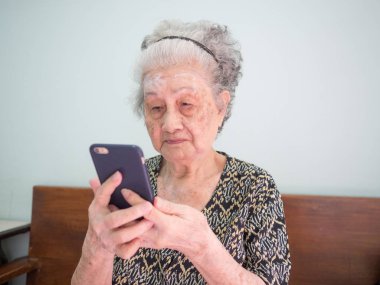 Yaşlı kadın diğer insanlarla iletişim kurmak için cep telefonunu kullanmayı öğrenerek kendini geliştirdi.