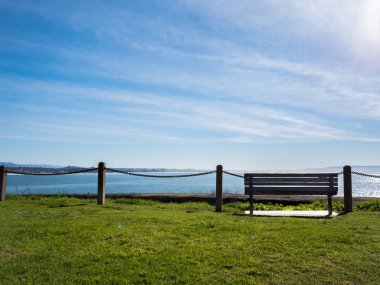 Geniş açık okyanus manzarası ve halka açık alanda bir sandalye..