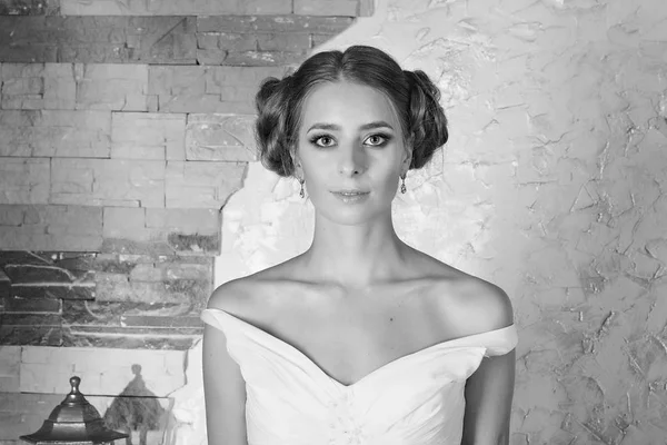 bride with a beautiful hairdo, on a brick wall background, black and white