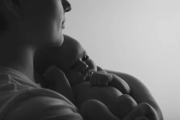 Fotografie v černé a bílé: matka drží svého syna v náručí. Rodinný portrét: žena s dítětem. Koncept zdravotní péče: zdravá rodina — Stock fotografie