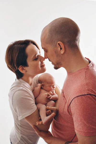 Familiefoto op een witte achtergrond: ouders brengen tijd door met hun kinderen. Mama en papa knuffelen de baby. het concept van kindertijd, vaderschap, moederschap, IVF — Stockfoto