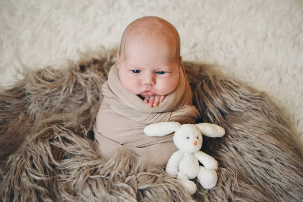 Een klein kind in een mand zuigt met speelgoed wit konijn. concept van kindertijd, gezondheidszorg, Ivf, gift, dier — Stockfoto