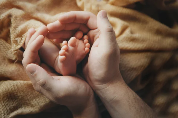 Pés de bebé recém-nascido. Mãe e pai segurando recém-nascido pernas do bebê, pernas conceito de massagem da infância, cuidados de saúde, FIV, higiene — Fotografia de Stock